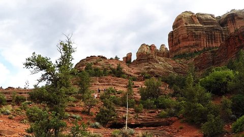 SEDONA, ARIZONA/USA: May 1, 2017- Distant people are seen on the side of Cathedral Rock climbing to the top. Cathedral Rock is a famous Sedona Landmark. 