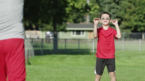 Father and son playing football in a park Stock Video