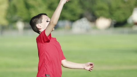 Young boy throwing a football. Arkivvideo