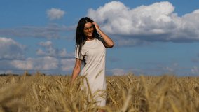 Young Happy brunette in yellow glasses is dancing in a wheat field 