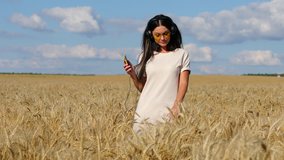 Music. Young beautiful woman listening to music with headphones standing in a wheat field 
