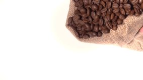 Coffee. Coffee beans are poured from the jute bag onto a white table.  Slow motion 240 fps. High speed camera shot. Full HD 1080p. 