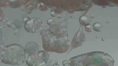 Translucent Oil Bubbles Background - A clearish but slightly tinted substance is poured into water and forms bubbles which rise to the surface
