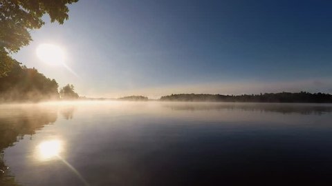 Time lapse of mist rising off of Canadian lake at sunrise