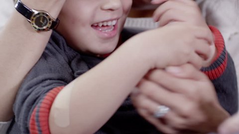 Little boy gets a sticking plaster on his arm