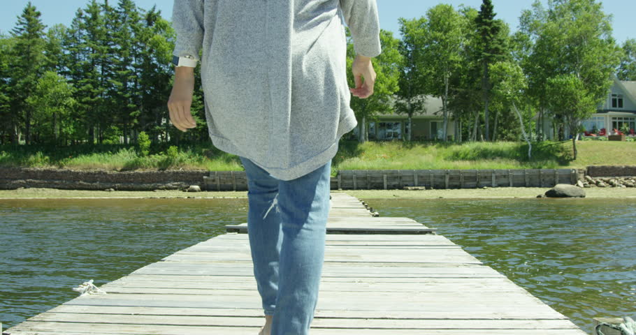 Mother walks down dock towards shore