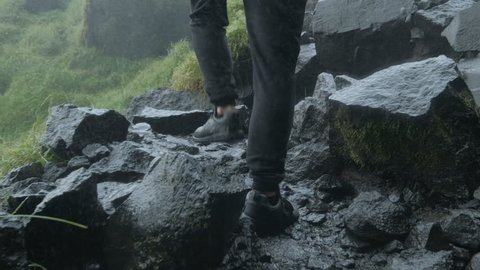 guy enters the sneakers on a mountain in the rain