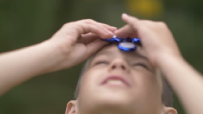 Happy boy twists the spinner on head Outdoors