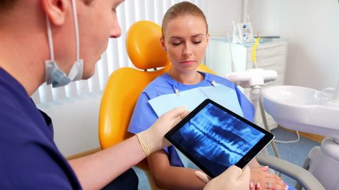 Patient is in the dentist office and listens to the explanations for x-ray image