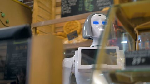 A robot helps customers to shop for bread.    