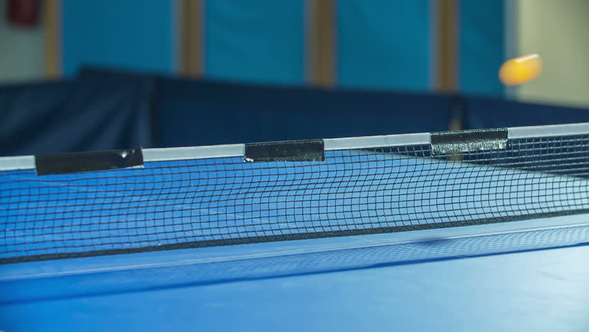 Yellow ping pong ball is travelling from one side to another. Kids are playing table tennis in a school gym. - Powered by Shutterstock - Get 15% off with code: PIKWIZARD15