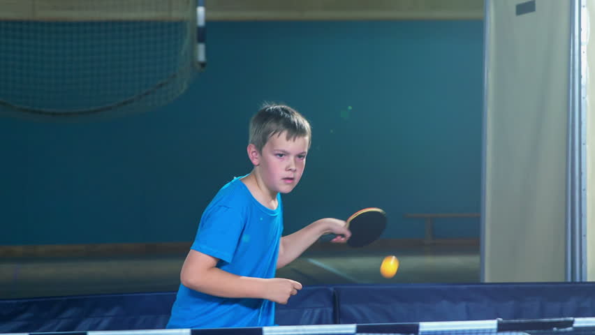 Two boys are playing table tennis in a school gym. They look very focused and dedicated. - Powered by Shutterstock - Get 15% off with code: PIKWIZARD15