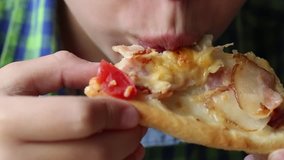 Closeup view of white little kid eating pizza at fastfood restaurant. Real time full hd video footage.