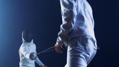 Two Professional Fully Equipped Fencers Expertly Fight with Foils. They Attack, Defend, Leap, Thrust and Lunge. Shot Isolated on Black Background. Shot on RED EPIC-W 8K Helium Cinema Camera.