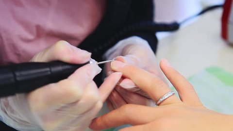manicure making female hands, covering of transparent enamel and nail varnish, nail polish.Woman hands in a nail salon receiving a manicure by a beautician. Woman getting nail manicure, spa treatments