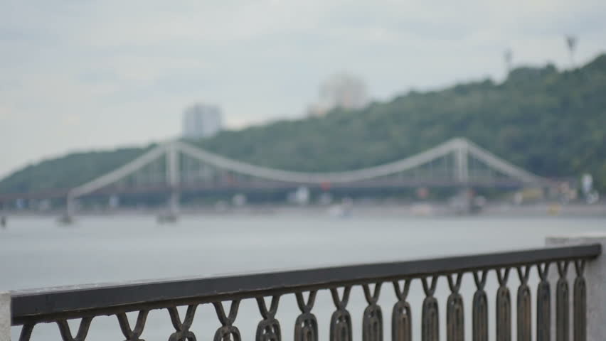 Attractive curly woman with tablet at the bridge background