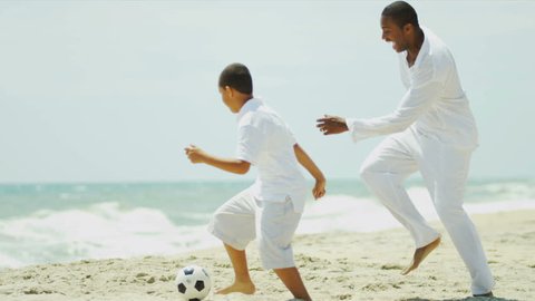 African American parent enjoying holiday with son playing soccer