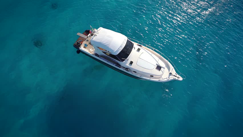 Motor boat mooring in the bay of Croatia. Amazing sea under boat, coral and stone pattern. Beautiful clean water. Sunny day in Croatia - pure water of ocean.