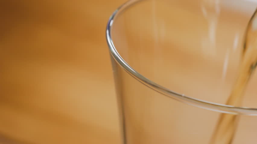 Close up pouring beer into glass