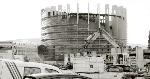 STRASBOURG, FRANCE - CIRCA 2016: Large construction site with European Parliament Headquarter building in Strasbourg in the background with Liebherr excavator working black and white