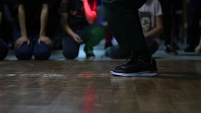 A view of the legs in black sneakers. A street dancer takes part in a dance competition in the style of hip hop.
