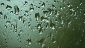 Rain drops on window glass closeup soft focus blur background