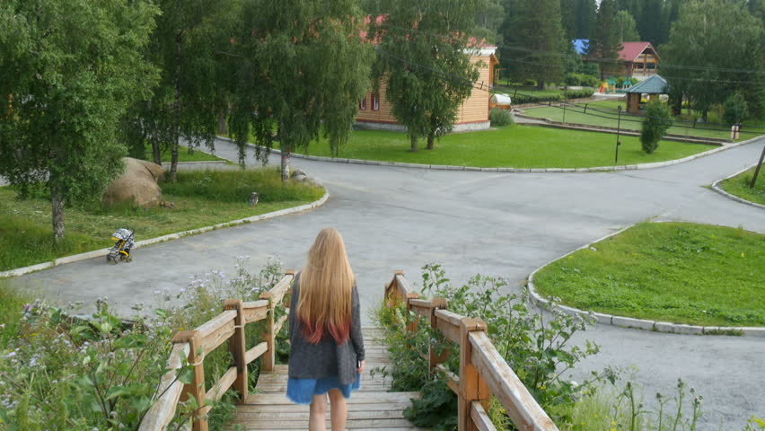 Girl in a skirt descends the wooden staircase