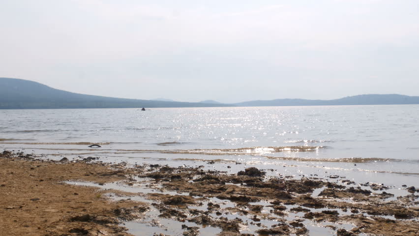 Boat sails to the shore of the lake