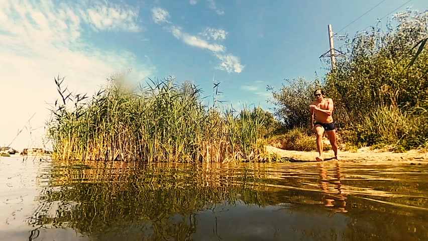 Slow Motion. The guy jumps slowly into the lake