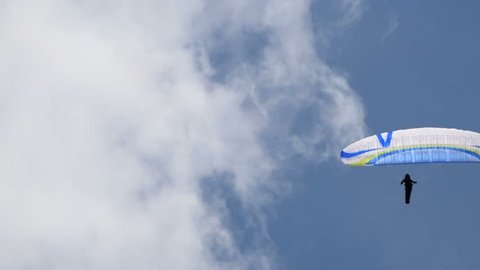 man manages paragliding on the blue sky