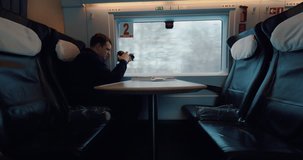 Man looking out the train window after finishing shooting video of outside scenes