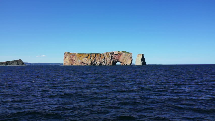 Boat view of Rocher Perce rock in Gaspe Peninsula, Quebec, Gaspesie region with dark blue water