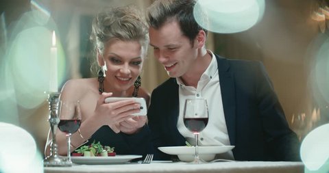 couple at the restaurant on the first date, the smartphone helps to find a way to communicate without shyness