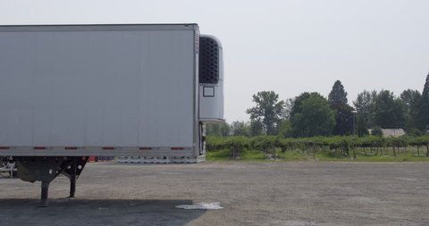 White truck cab reverses and makes connection to white trailer on summer day in rural area. Side view, real-time 4K.