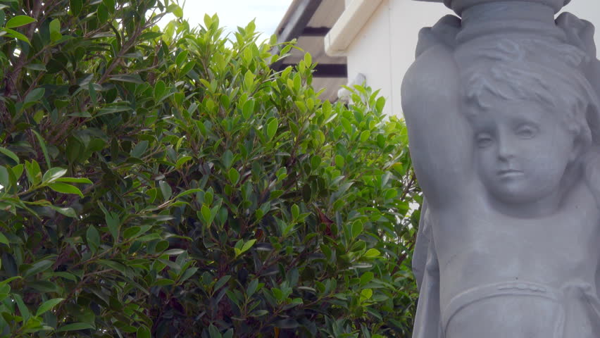 statue in the middle of a beautiful garden and blue sky background