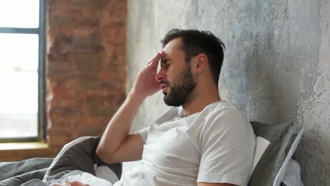 Poor millennial guy struggling with severe headache