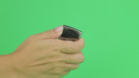 Hand Lighting up a zippo Lighter. Ignites the lighter on a green screen. Using a lighter on a green screen. 