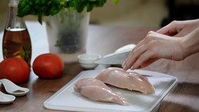 The cook cuts the chicken breast, raw chicken, chef cooks chicken breasts, poultry meat, diet meat