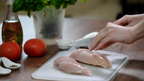 The cook cuts the chicken breast, raw chicken, chef cooks chicken breasts, poultry meat, diet meat