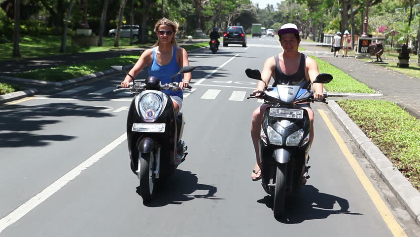 People driving on mopeds on street