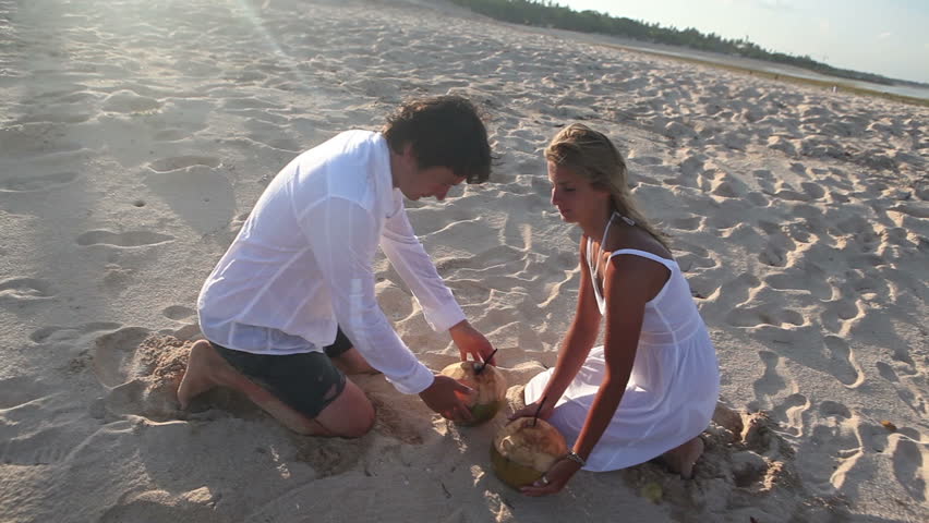 Happy couple drinking coconuts then going away