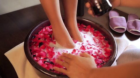 Foot Spa massage pouring milk in bowl of rose petals
