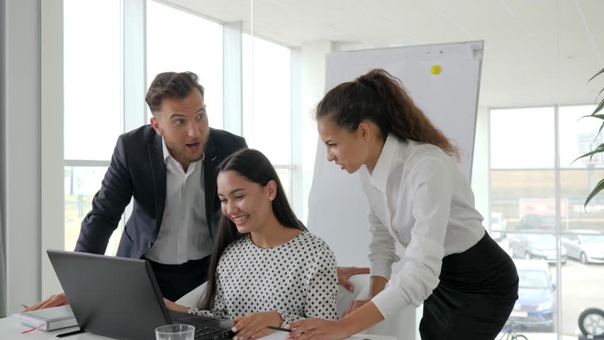 Young successful people in modern office, emotional employees working over computer screen | Shutterstock HD Video #30918382