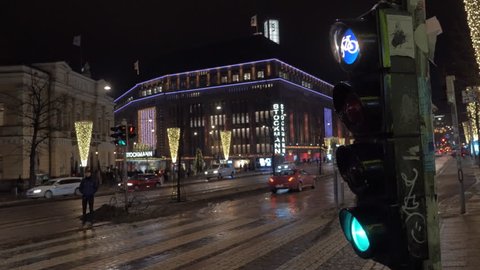 HELSINKI, FINLAND - JANUARY 07, 2017: Cars driving in night street. View to Stockmann shopping mall and the traffic lights in foreground