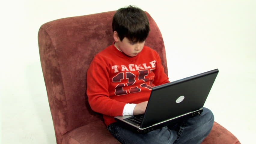 A young boy uses his laptop to do homework. -D-