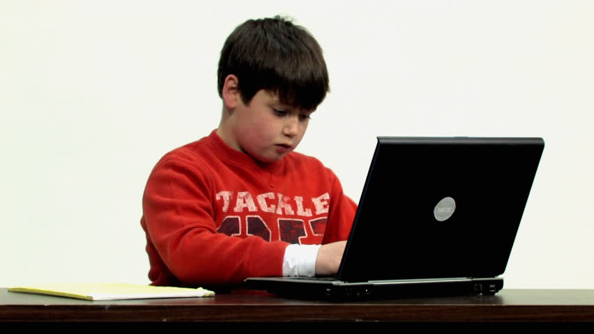 A young boy uses his laptop to do homework. -D-
