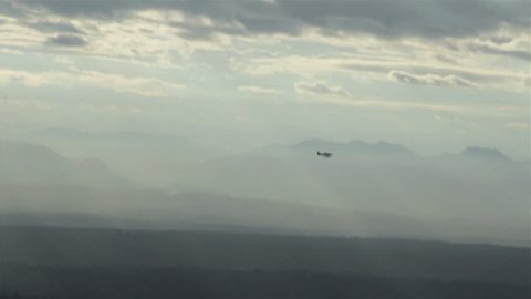 View from airplane of float plane silhouette flying in front of mountain range