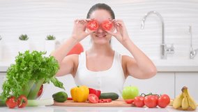 Beauty young woman holding fresh tomatoes vegetables and smiling in her kitchen at home. Healthy eating concept. Diet, dieting, slimming, weight loss.Beautiful girl Cooking. Healthy Lifestyle 4K UHD