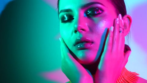 High Fashion model woman in colorful bright lights posing in studio, portrait of beautiful sexy girl with trendy make-up and manicure. Art design, colorful make up. Over colourful vivid background 4K