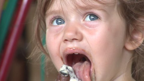 Cute blue-eyed girl licking an ice-cream
